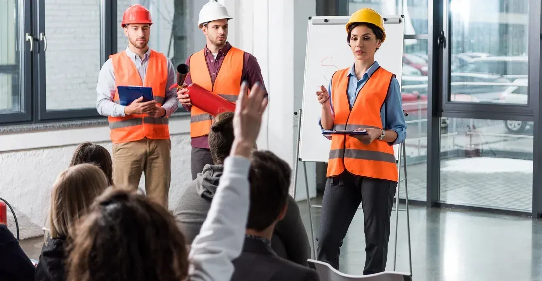 selective focus of firemen in helmets standing near attractive firefighter giving talk near white